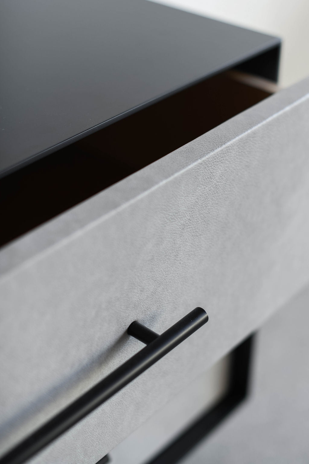 close up on drawer with leather face and metal handle 